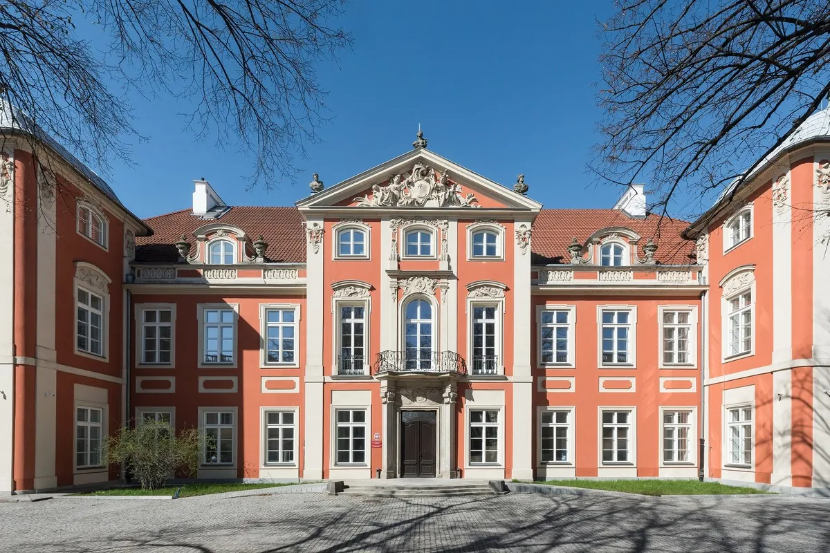 Die rosa-weiße barocke Fassade des Czapski-Palasts in Warschau, gesehen über einen Innenhof an einem klaren Tag